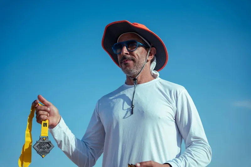 Adel Beznine holding a tenth-edition finisher medal.